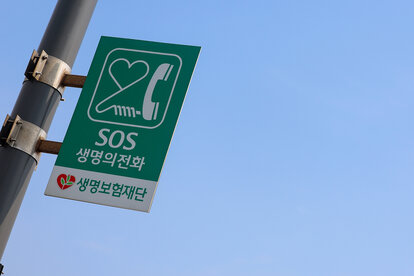Schild mit einem speziellen Telefon, das auf der Mapo-Brücke über den Han-Fluss in Seoul installiert wurde, die schon oft als Selbstmordziel aufgefallen ist, um Selbstmord zu verhindern.