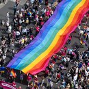 Menschen ziehen auf der 45. Berlin Pride-Parade zum Christopher Street Day (CSD) mit einer überdimensionalen Regenbogenfahne durch die Stadt. 