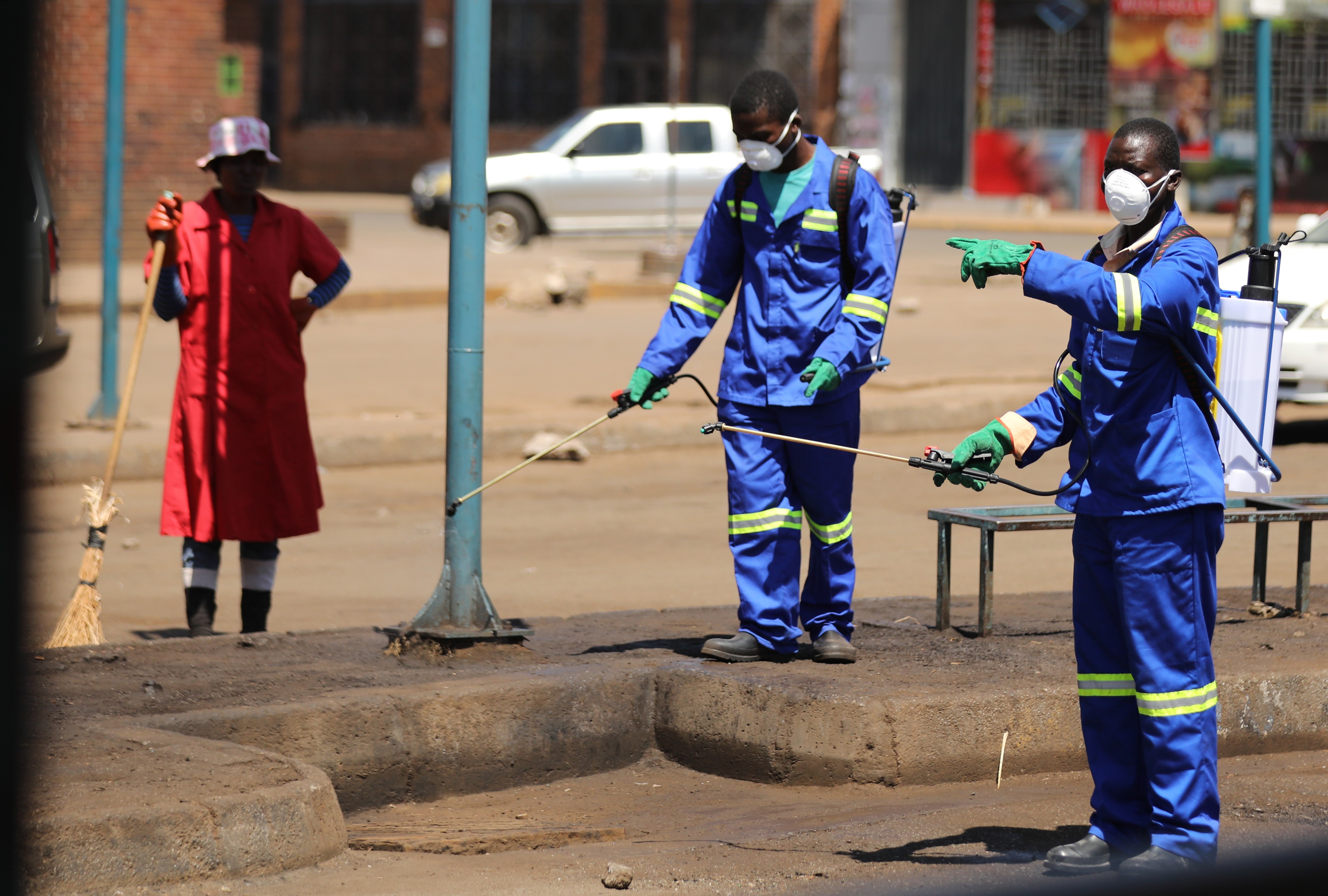 Reinigungskräfte deifizieren hier eine Busstation in Harare. 