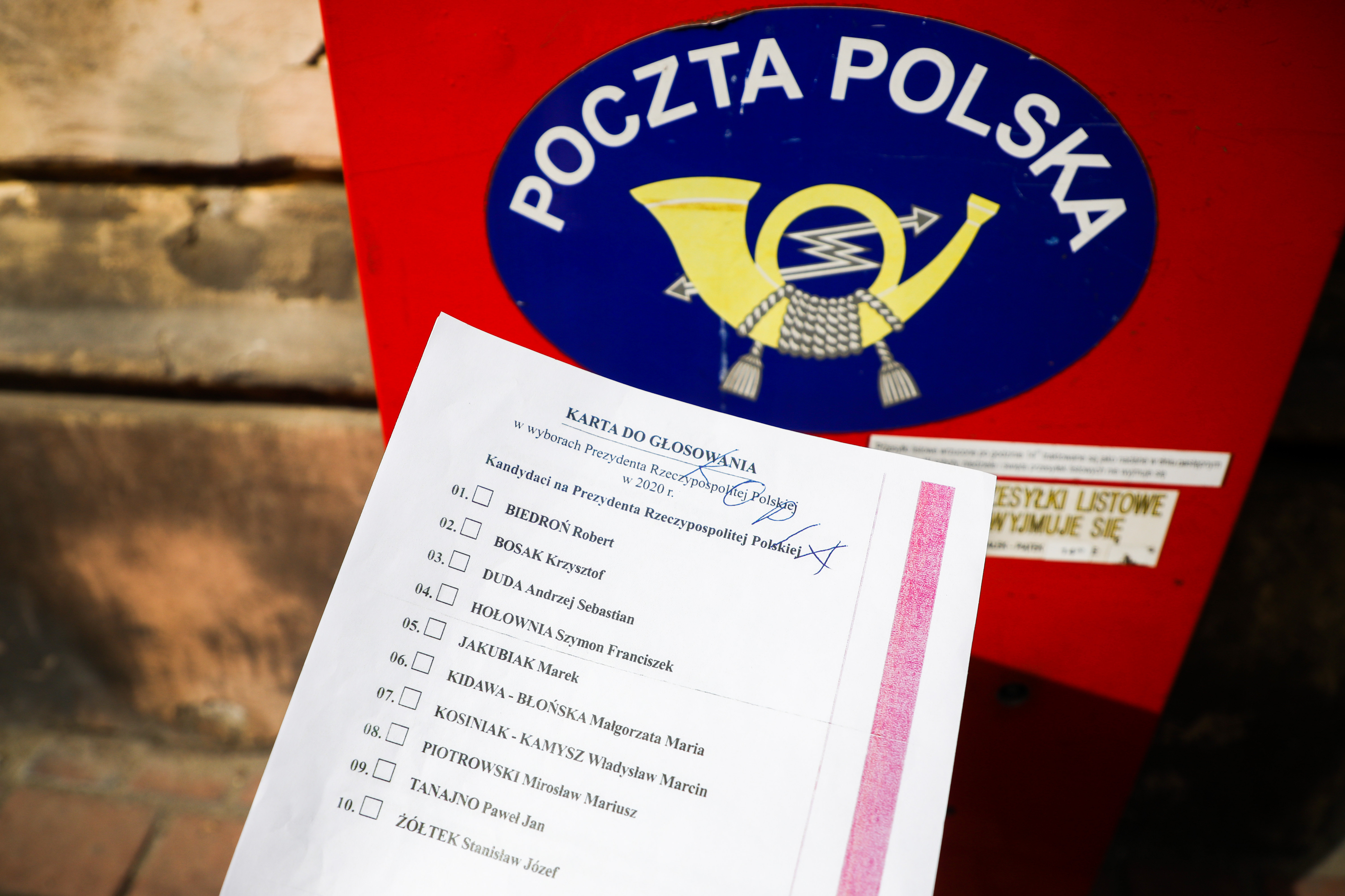 A copy of the 'election package' documents is photographed for illustration photo with Poczta Polska mailbox in the background. Krakow, Poland on May 2nd, 2020. A voting package leaked in the upcoming correspondence election with a full list of candidates for Presidential office and with name and surname statement on secret voting. Despite coronavirus pandemic, Poland's government plans to hold the presidential election on May 10 in the form of a correspondence vote.
