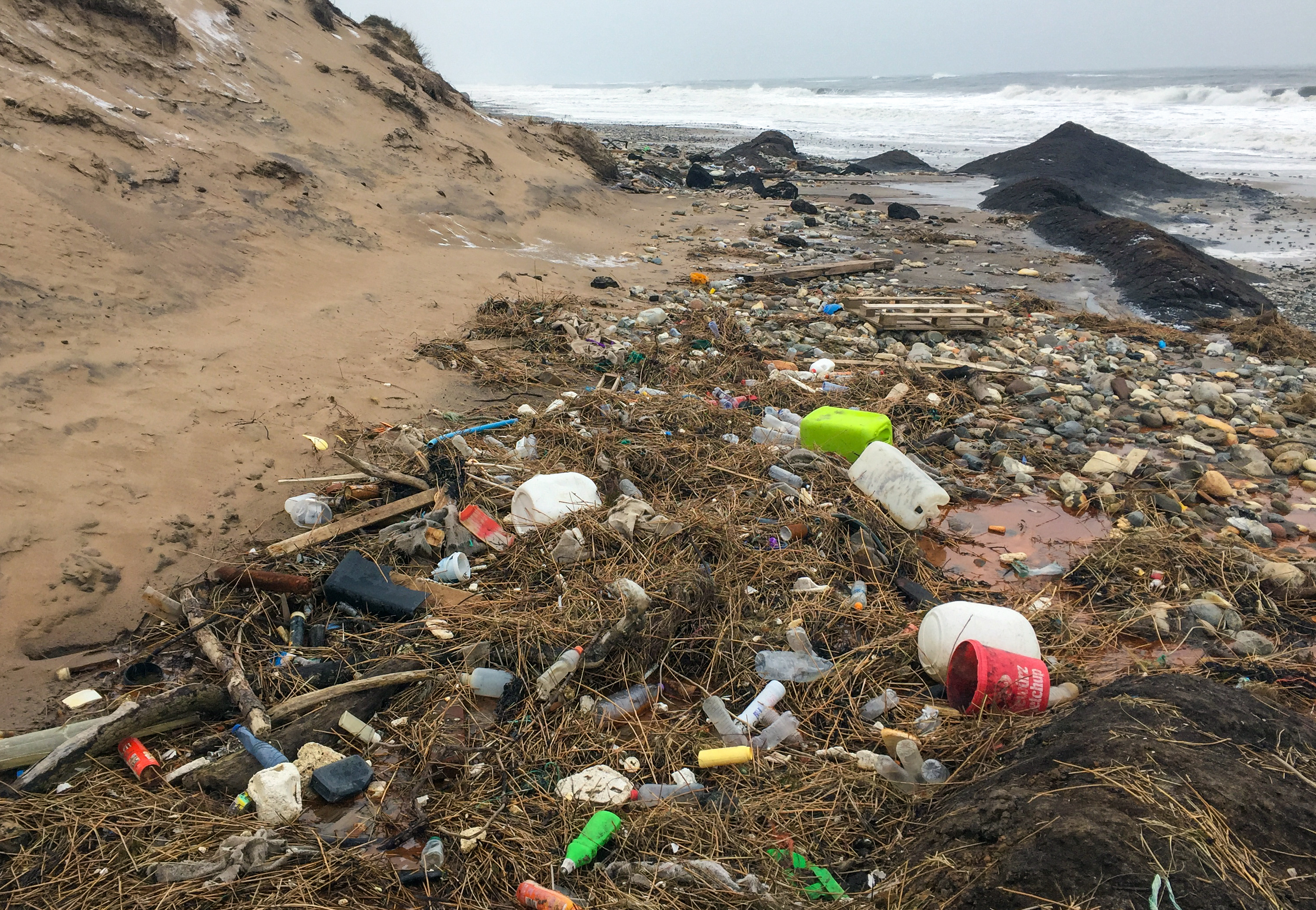 Angespülter Plastikmüll, Holz und Fässer liegen am Strand der Nordsee im Gebiet des Nationalparks Thy