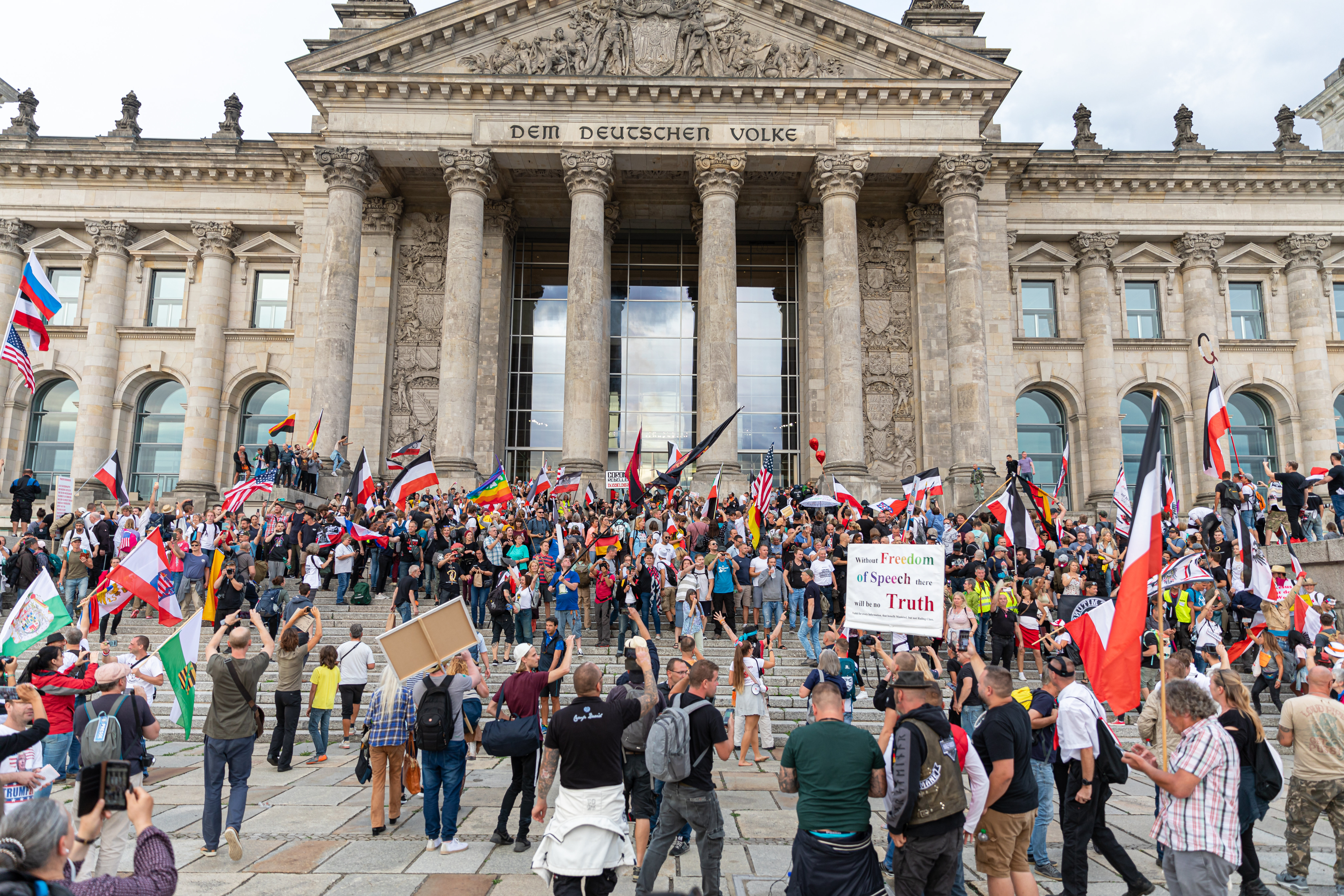 Demonstranten schwenken Reichskriegsflaggen vor dem Reichstag