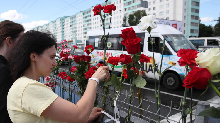 Menschen legen Blumen für eine bei den Protesten getötete Person nieder