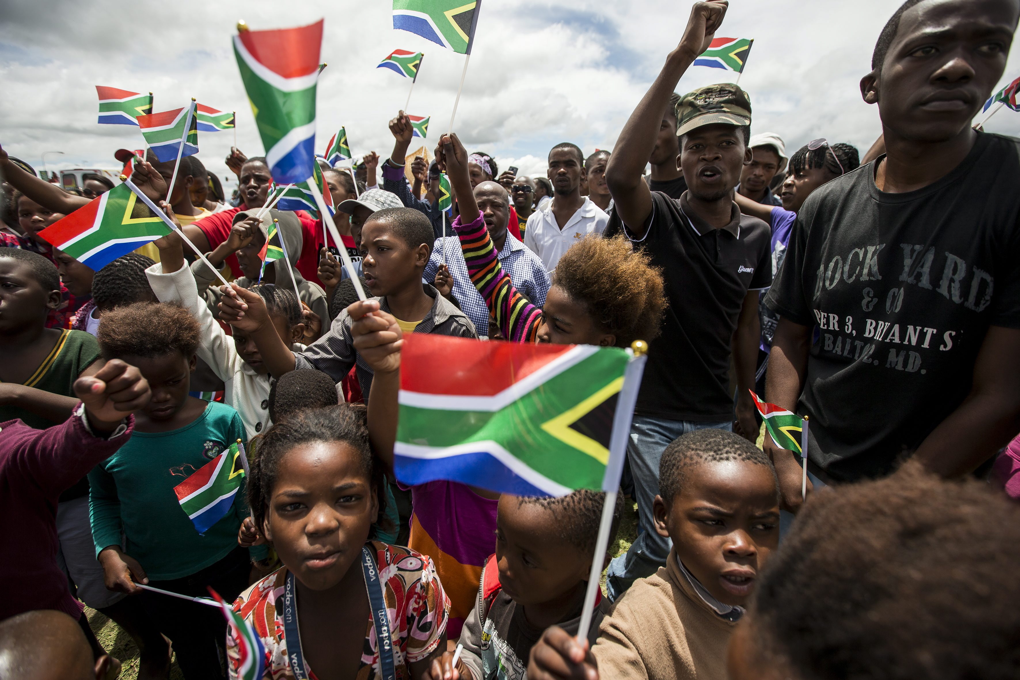 Mit Regenbogenfahnen wedelnde Unterstützer Mandelas auf dessen Beerdigung 2013