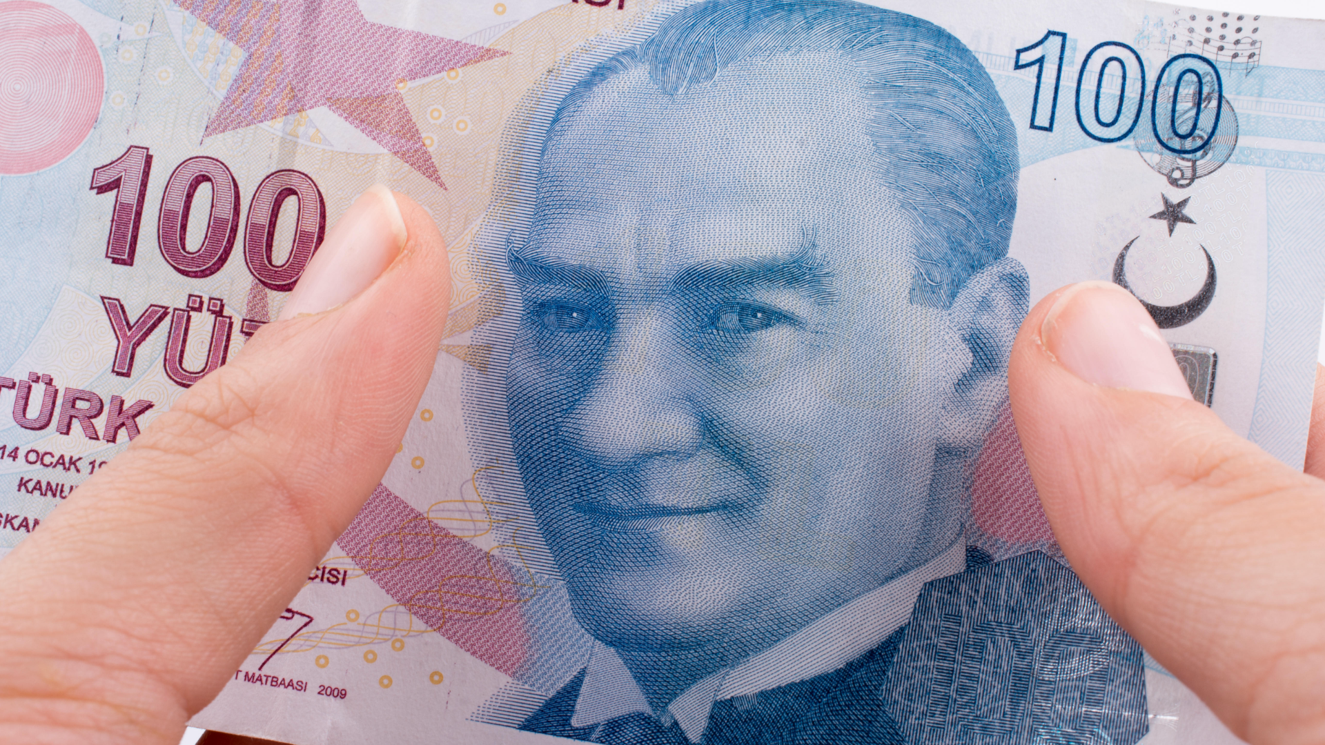 Hand hält 100 Türkische Lira Banknoten auf weißem Hintergrund