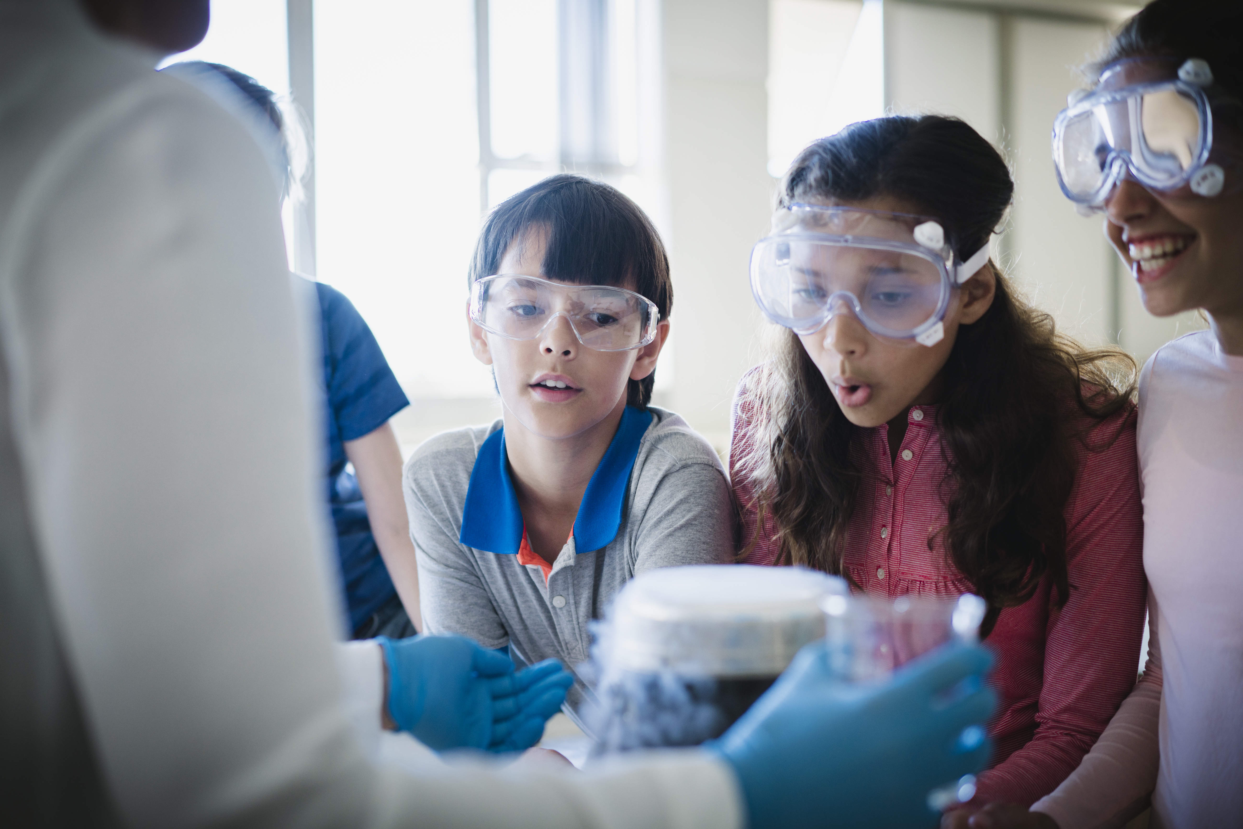 A photo of curious students looking at scientific experiment. 