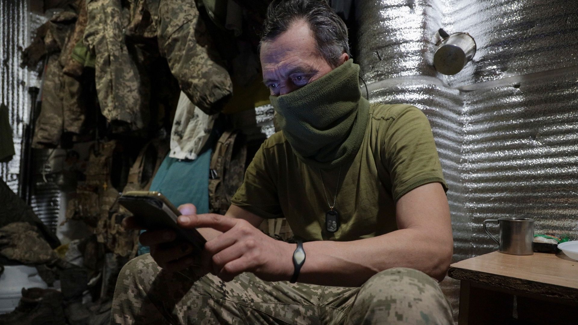 A Ukrainian serviceman looks at his phone 