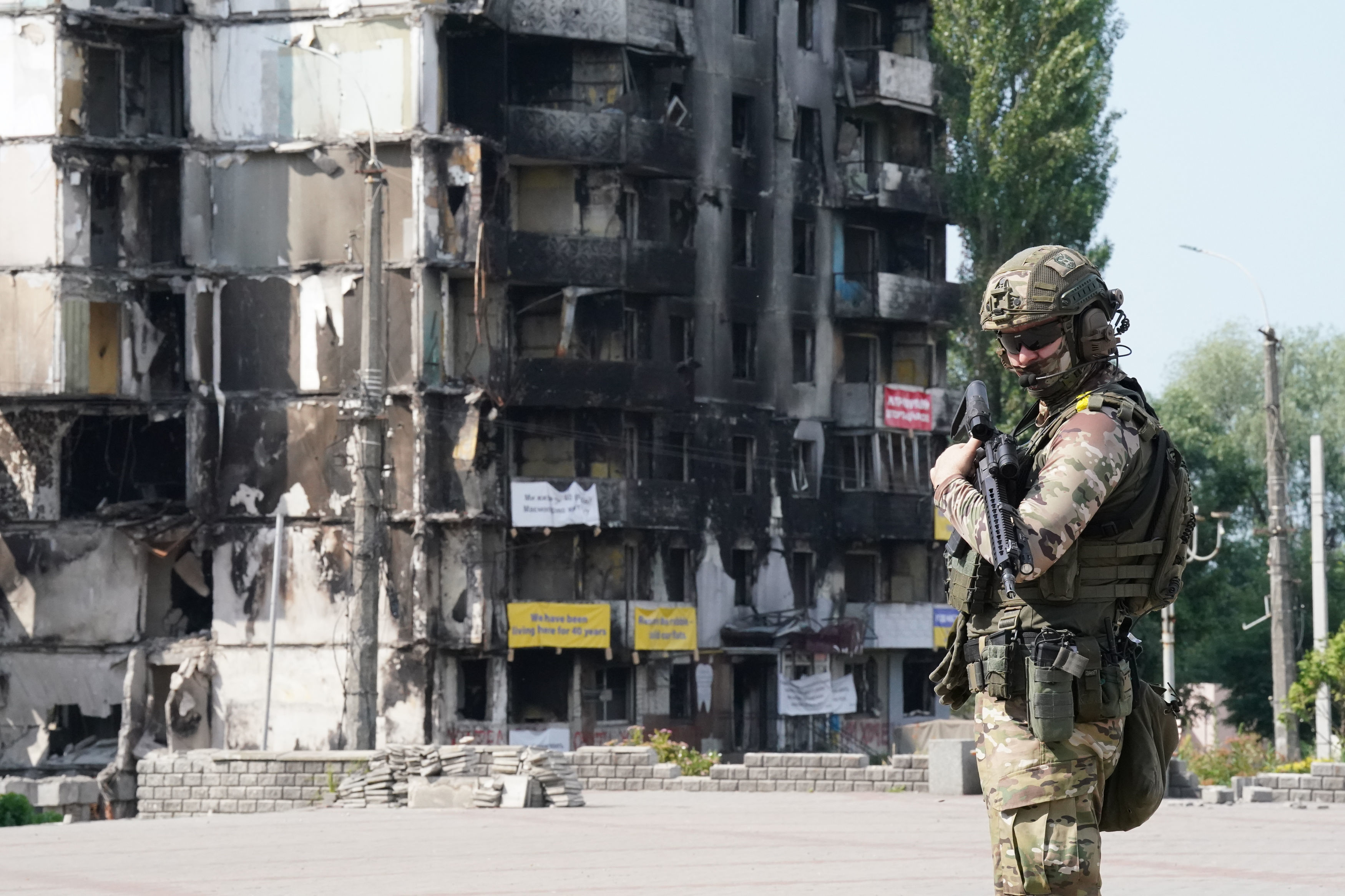 Ein Mitglied des ukrainischen Militärs steht vor beschädigten Gebäuden im Kiewer Stadtteil Borodyanka