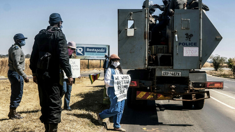 Der simbabwische Schriftsteller Tsitsi Dangarembga  und seine Kollegin Julie Barnes halten Plakate, als sie während eines Protestmarsches gegen Korruption auf der Borrowdale Road am 31. Juli 2020 in Harare verhaftet werden.