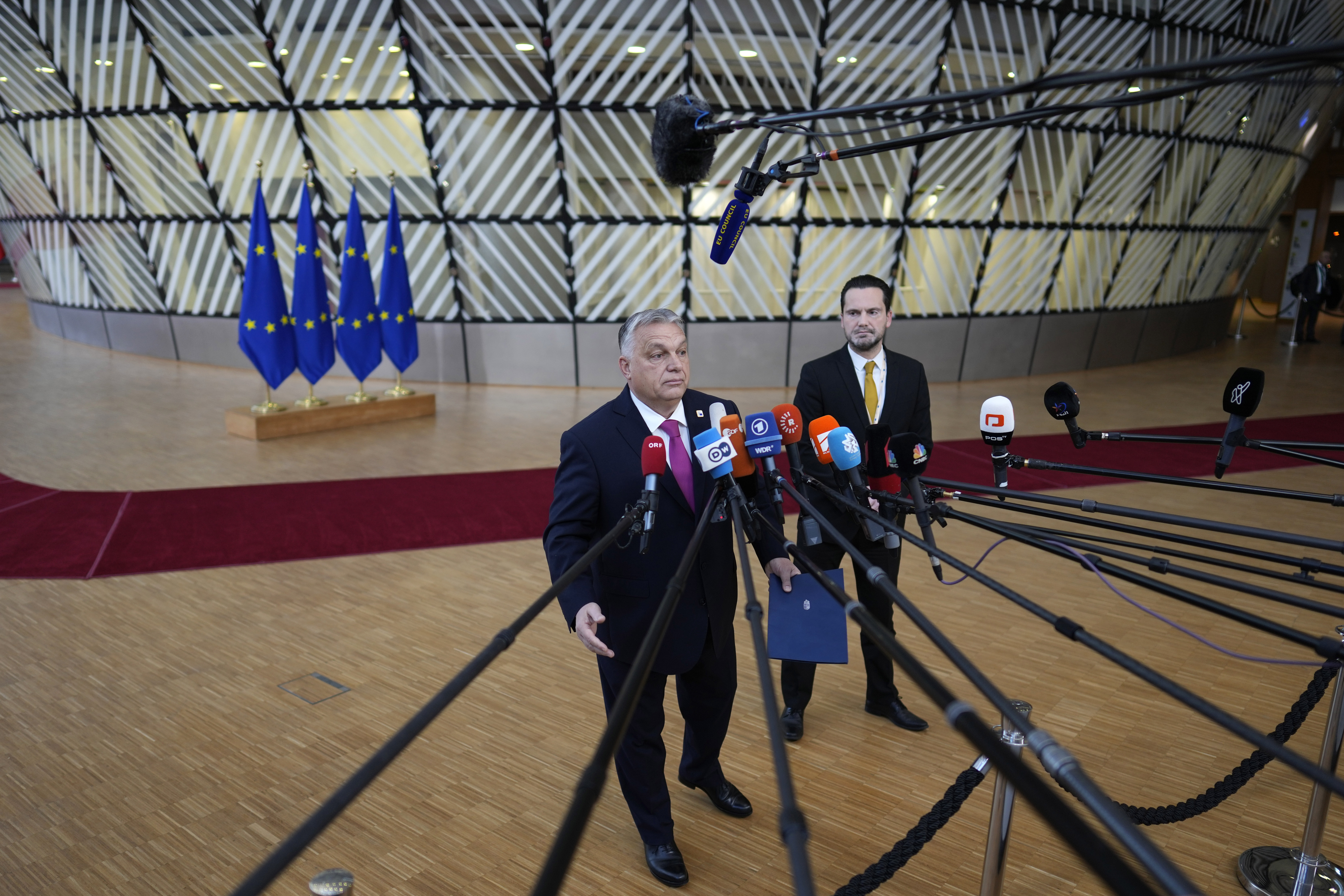 Hungary's Prime Minister Viktor Orban speaks with the media as he arrives for an EU summit at the European Council building in Brussels