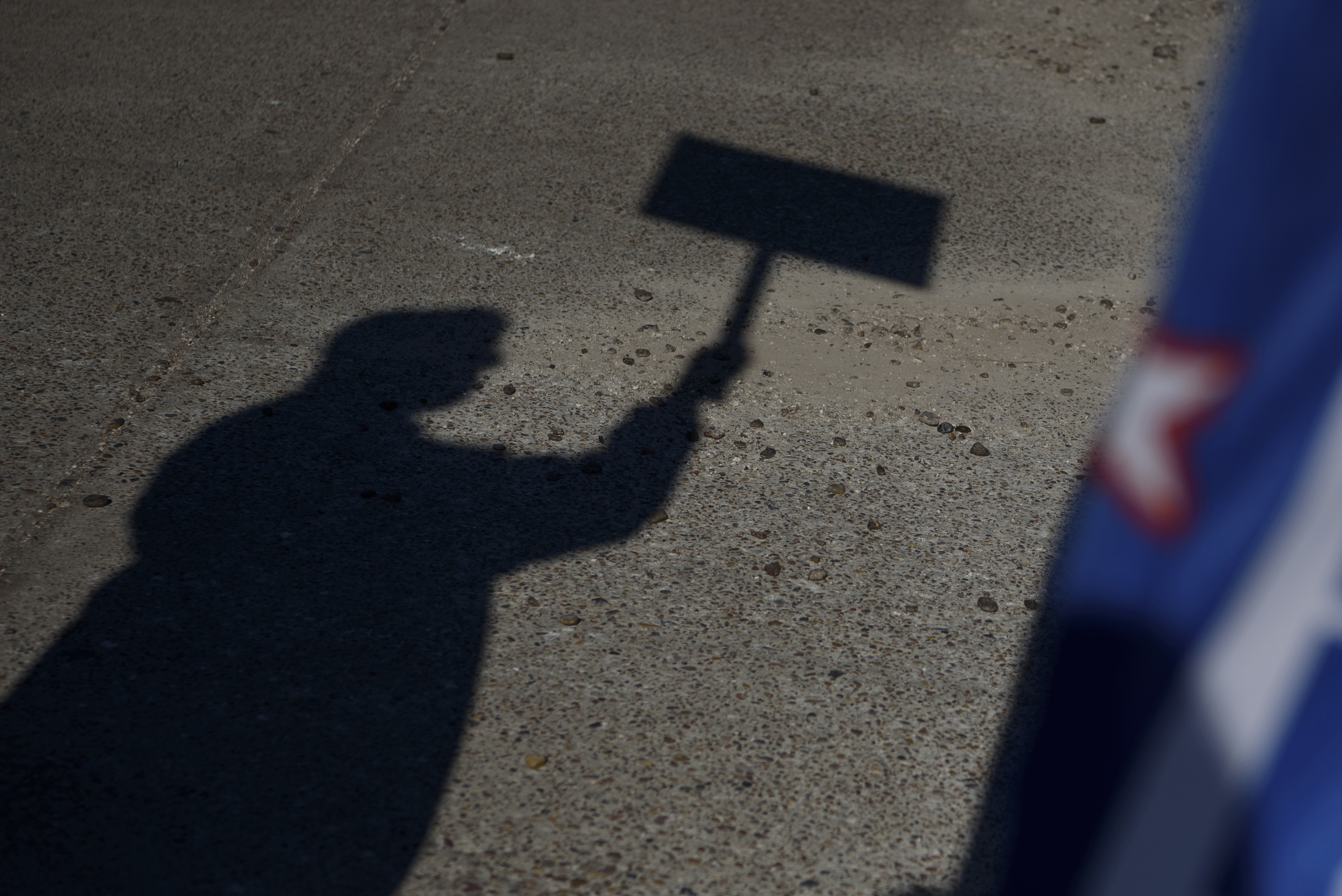 The shadow of a voter holding a campaign sign. Photographer: Callaghan O'Hare/Bloomberg