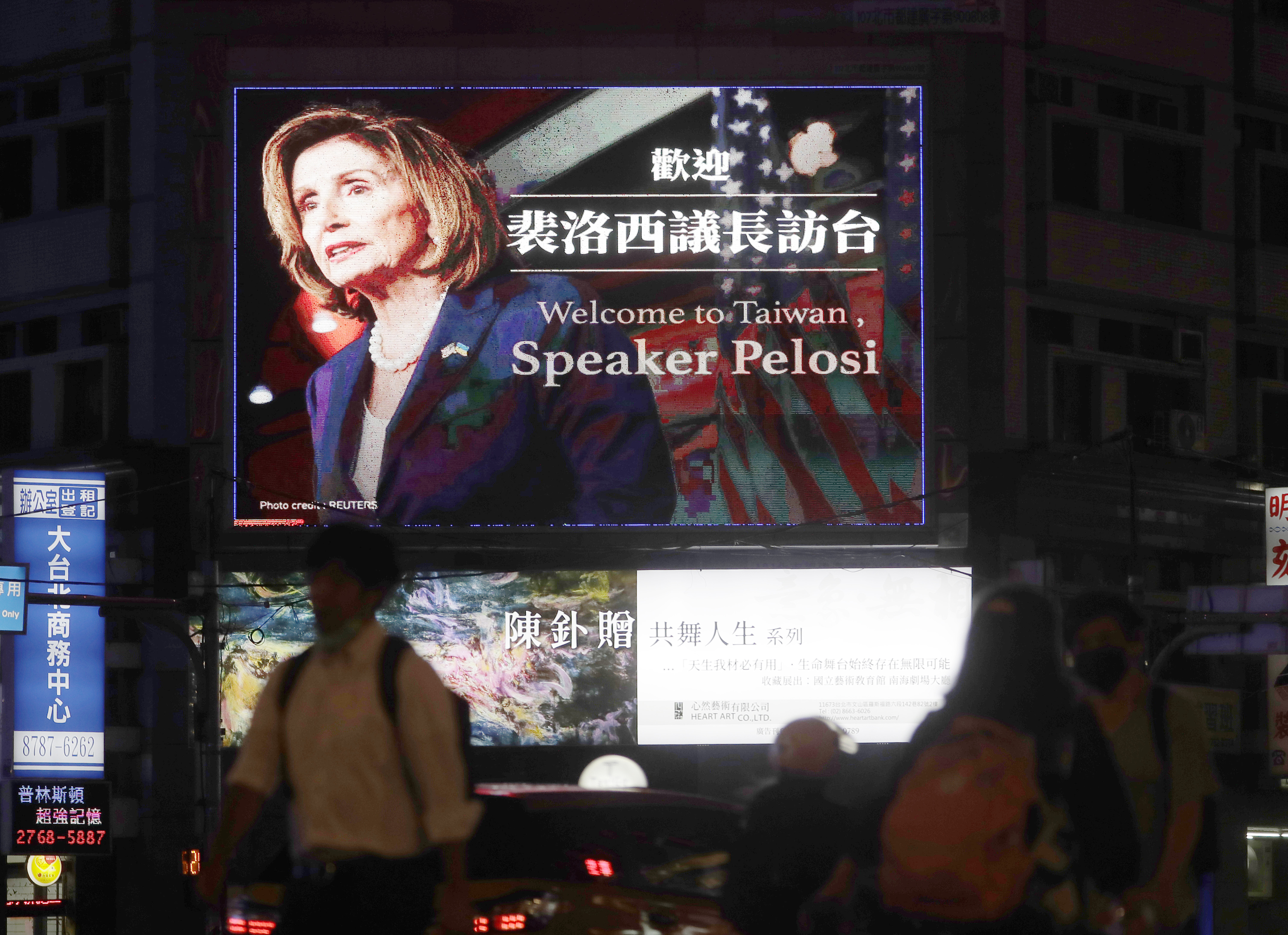 Menschen gehen an einem Plakat vorbei, das die Sprecherin des US-Repräsentantenhauses, Nancy Pelosi, in Taipeh, Taiwan, am Dienstag, 2. August 2022, begrüßt.