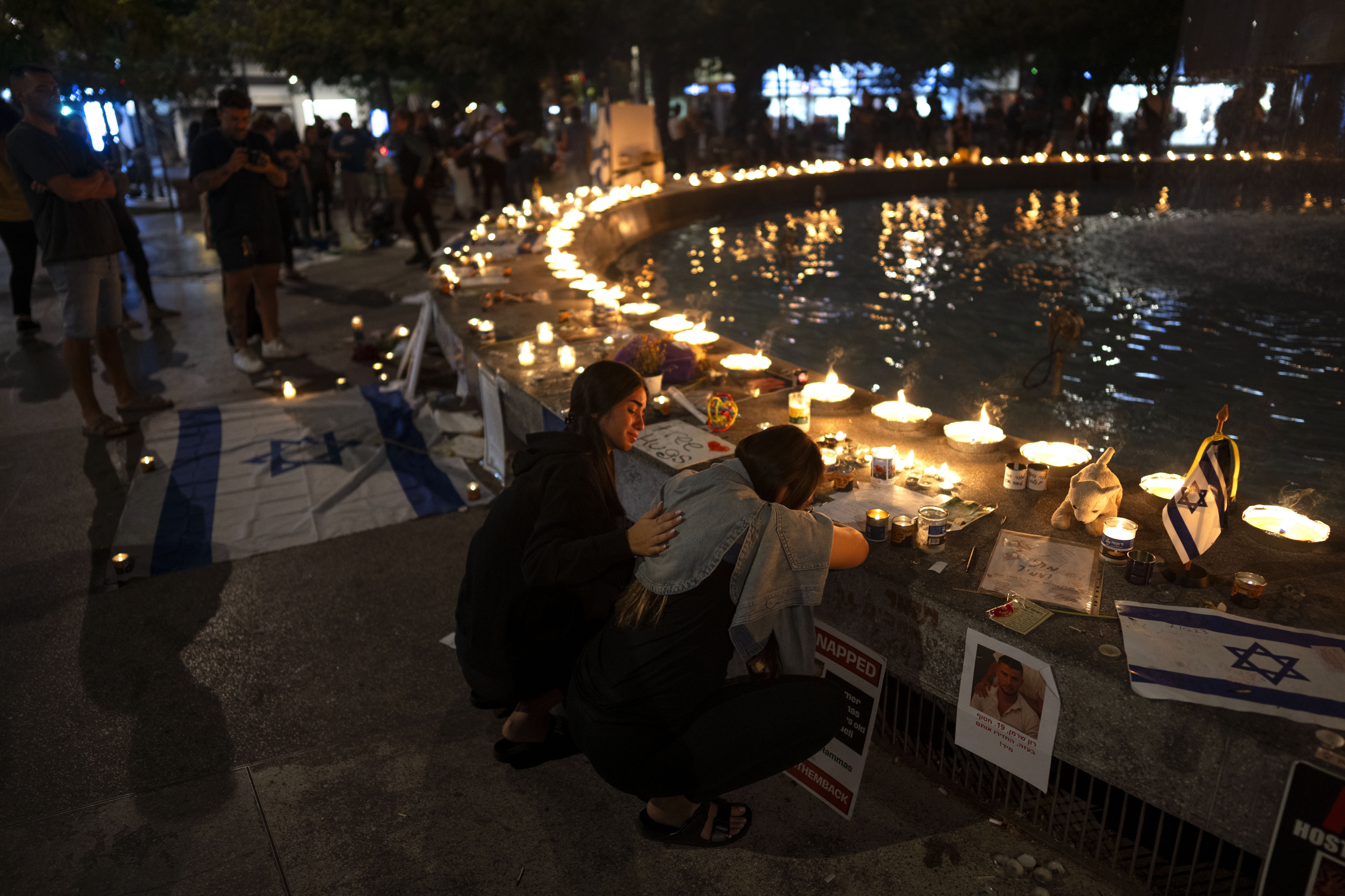 Menschen nehmen an einer Mahnwache bei Kerzenlicht teil