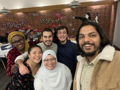 Nurhuda Ramli (author) in a group selfie with other IAF participants in some sort of a gathering room. Behind them is a wall with two words, "Freiheit" and "Freedom", written on it.