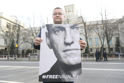 Ein Unterstützer hält ein Plakat mit dem Bild des russischen Aktivisten Alexej Nawalny vor der russischen Botschaft in Berlin. Nach Angaben der Justiz in seiner sibirischen Strafkolonie ist Nawalny am Freitag im Alter von 47 Jahren gestorben.
