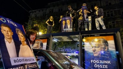 A crowded, dramatic street scene lit by bright city lights.