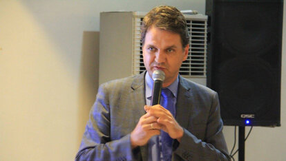 Dr. Roland Schissau of the German Embassy addresses the alumni group