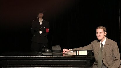 Robert Mohr (Lena Riedel) beim Verhör von Sophie Scholl. Im Hintergrund ein SS- Mann (Tabea Tafel)