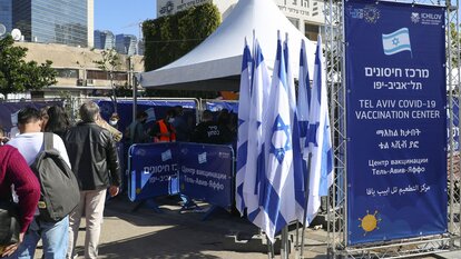 Menschen warten in einer Schlange vor einem Veranstaltungsort in Tel Aviv auf die Impfung für ausländische Einwohner in Israel