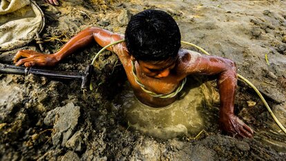 Ein Kind bereitet sich auf den nächsten Tauchgang auf der Suche nach Gold vor. Der Kompressor-Schlauch ist unter Wasser sein einziger Lebensfaden. Gumaus, Paracale, Provinz Camarines Norte