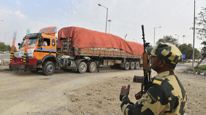 Ein indischer Soldat bewacht einen mit Weizen beladenen Lastwagen