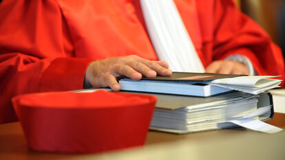 Ein Richter des Zweiten Senats beim Bundesverfassungsgericht in Karlsruhe hält am Dienstag (28.10.2008) bei der mündlichen Verhandlung über zwei Wahlprüfungsbeschwerden gegen den Einsatz von mehr als 1800 Wahlcomputern bei der letzten Bundestagswahl, eine Hand auf seine Unterlagen. Foto: Uli Deck dpa/lsw +++(c) dpa - Report+++