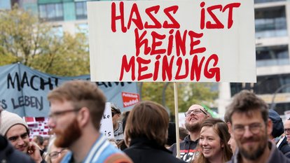 Mit Schildern, unter anderem mit der Aufschrift "Hass ist keine Meinung", ziehen Teilnehmer bei einer bunten Parade gegen Rassismus durch die Innenstadt. 