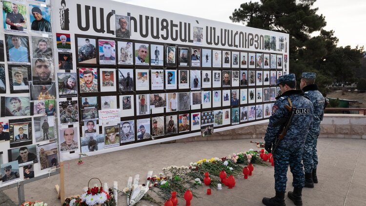 Armenische Polizisten vor einem Mahnmal für die gefallenen Soldaten des Krieges um Bergkarabach