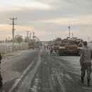 Soldaten gehen an der Grenze zwischen der türkischen Stadt Akcakale und der syrischen Stadt Tall Abyad in einem Aufenthaltsbereich für die türkischen Streitkräfte und die türkisch unterstützte syrische Nationalarmee und warten auf ihren Einsatz.