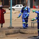 Reinigungskräfte deifizieren hier eine Busstation in Harare. 
