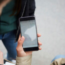 Ein Frau hält ein Smartphone in der Hand.