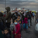 Migranten gehen im Hafen von Piräus bei Athen an Land.