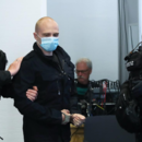 Der angeklagte Stephan Balliet (r) wird von Justizbeamten zu Prozessbeginn in den Gerichtssaal im Landgericht geführt.