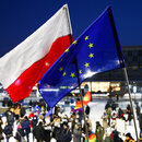 Demonstranten protestieren in Krakau mit der polnischen und der EU-Flagge gegen die geplante Mediensteuer