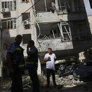 Petach Tikwa, Israel, Menschen vor den Trümmern ihres Wohnhauses, das in der Nacht von einer Rakete aus dem Gazastreifen getroffen wurde.
