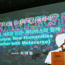 The speaker is starting a presentation with the screen behind him. 