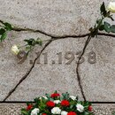 Rosen stecken in Rissen am Mahnmal. Darunter steht das Datum der Reichsprogromnacht.