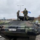 Zwei deutsche Soldaten stehen auf einem Schützenpanzer Puma vor der Militärparade.