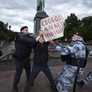 Polizeibeamte halten einen Demonstranten mit einem Plakat fest, auf dem zu lesen ist: "Freiheit für Alexej Nawalny"