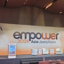 A view of the Asia Liberty Forum 2024's stage. A podium is seen standing a few metres apart from three single seats reserved for speakers.