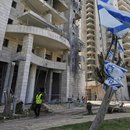 Ein israelischer Sicherheitsbeamter steht am Eingang eines Wohngebäudes, das von einer aus dem Iran abgefeuerten Rakete getroffen wurde