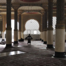 Un homme porte un tapis dans  la Grande Mosquée de Touba, au Sénégal.