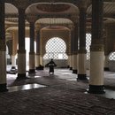 Ein Mann trägt einen Teppich in einem Gebetsraum in der Großen Moschee in Touba, Senegal,