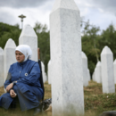Eine Frau trauert neben dem Grab ihres Verwandten, eines Opfers des Völkermordes von Srebrenica.