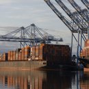 Die Sonne geht über Containerschiffen auf, die in einem Hafen in den Vereinigten Staaten vor Anker liegen.