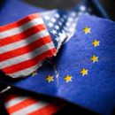 Angerissene und ineinander verkeilte EU- und USA-Fahne, Symbolfoto Zollstreit und Zoll-Deal 