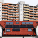 Hohe Wohnhäuser sind am 21.11.2024 in München (Bayern) hinter dem Dach eines modernen Mehrfamilienhauses zu sehen. 