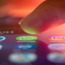 Finger über dem Smartphone, kurz vorm Öffnen einer Messenger-App