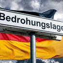 Warnschild ‚Bedrohungslage‘ vor der deutschen Flagge
