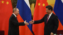Russian President Vladimir Putin, left, shakes hands with Chinese President Xi Jinping